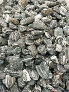 Siyah çakıl taşları, dış mekanlarda kontrast oluşturmak ve şıklık katmak için ideal bir dekorasyon malzemesidir